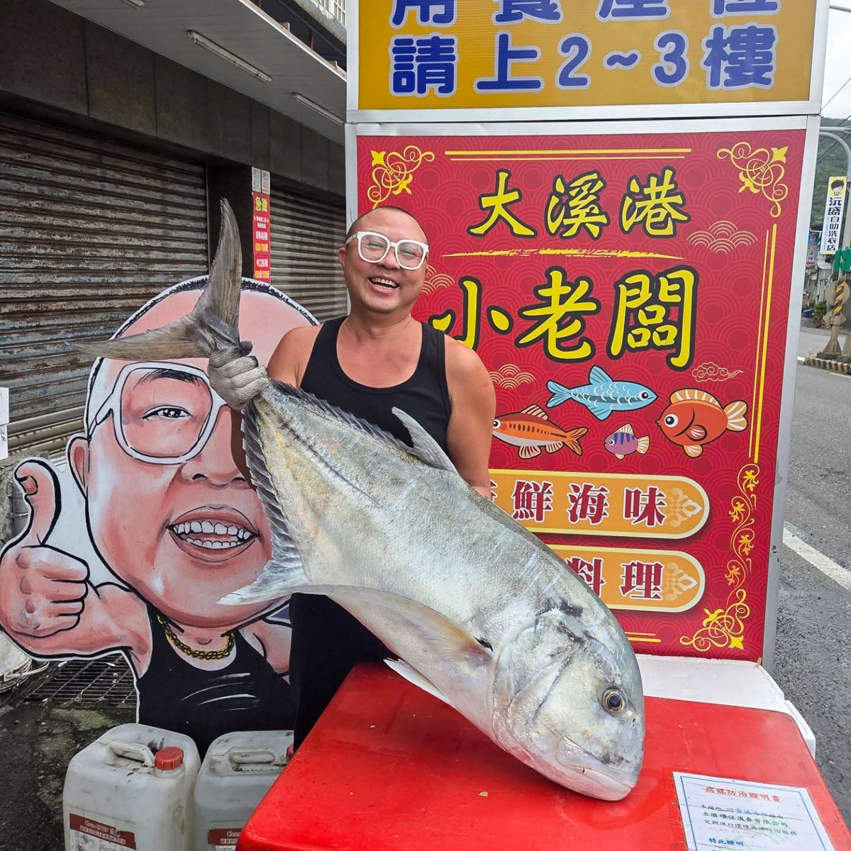 大溪港小老闆招牌前,人物展示一尾大型魚獲